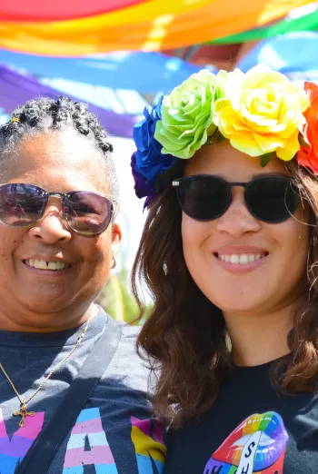 A photo capturing community members at a local pride celebration, highlighting diverse faces and an inclusive atmosphere
